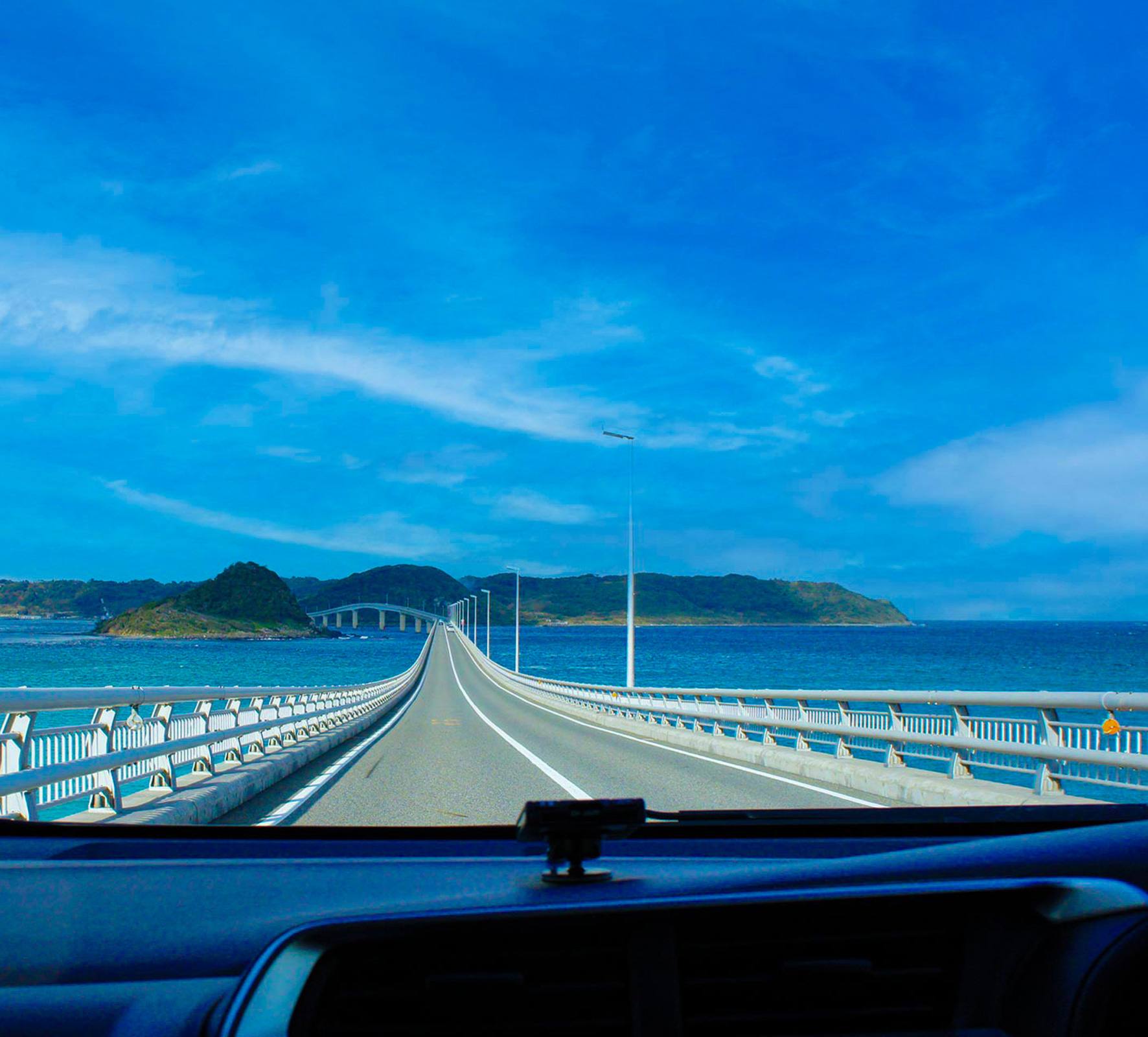 コバルトブルーの海の上の橋をドライブしている車内から撮った写真